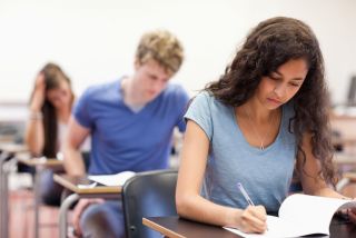 Jeunes étudiants travaillant sur un devoir dans une salle de classe